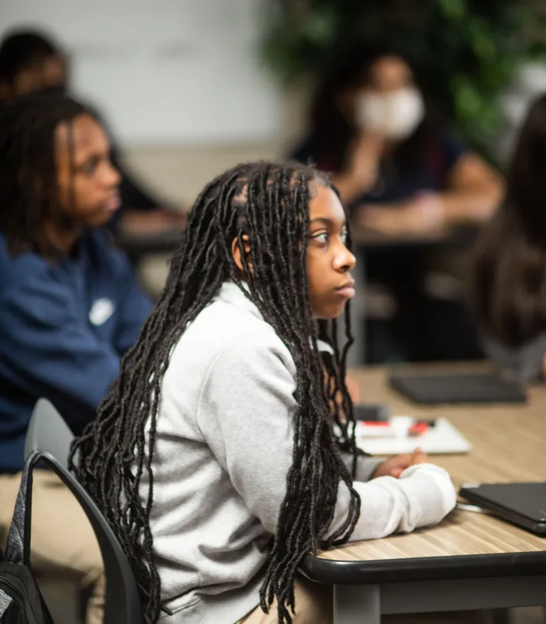 Children in a classroom listening to a teacher