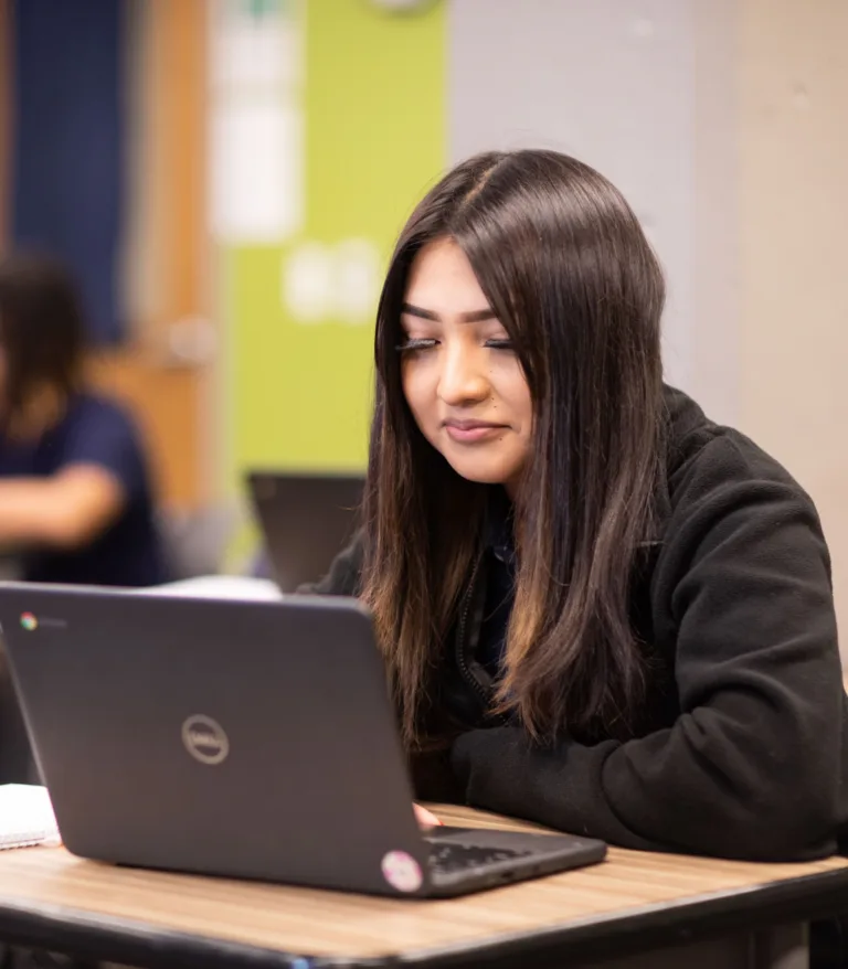 A student using her laptop in a classroom