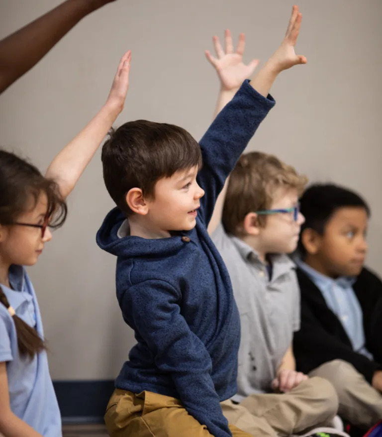 A group of children raising their hands