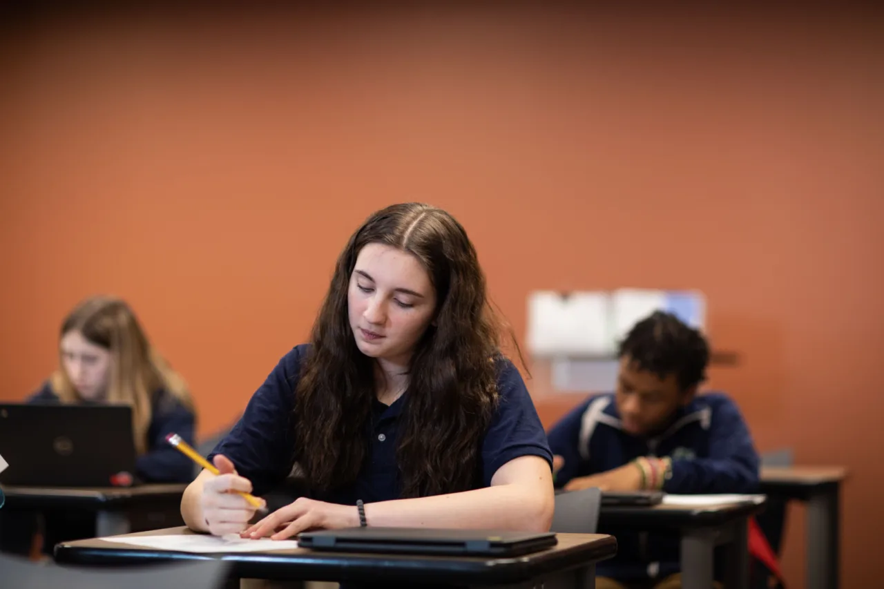 A group of students taking notes at their desks