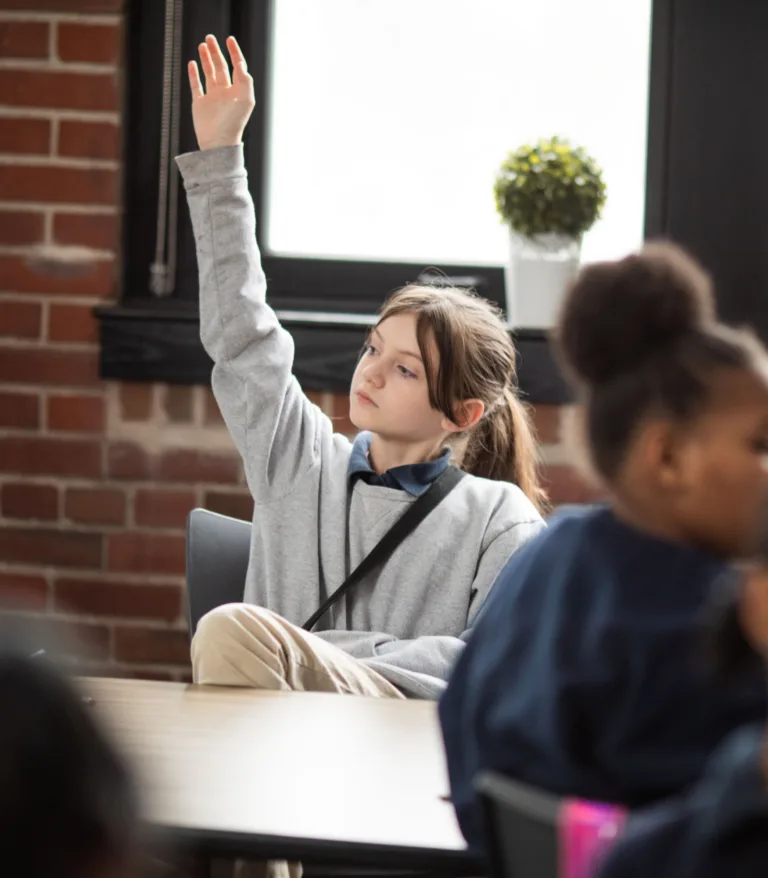 A girl raising her hand in class