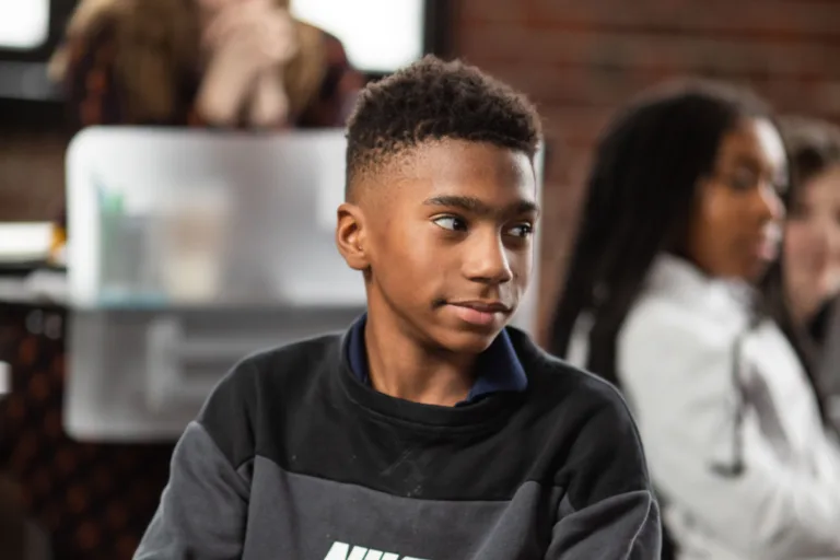 A student listening at their desk to a lesson